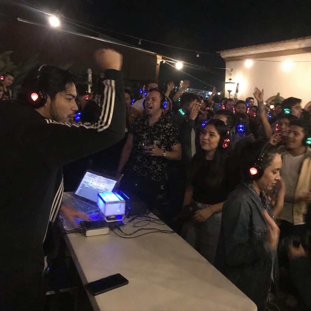 DJ playing to a crowd wearing LED headphones